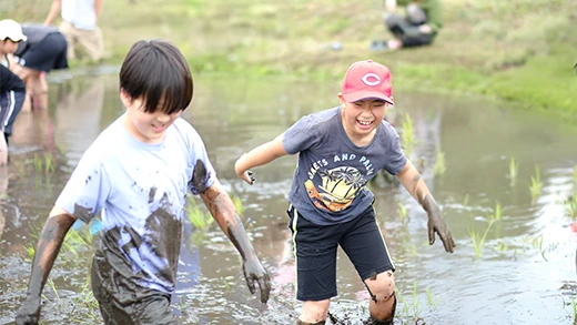 田植えを楽しむこどもたちの写真