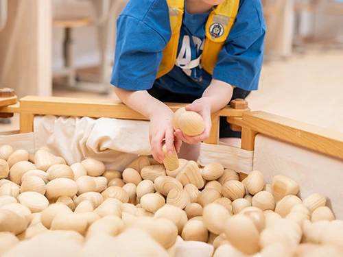 木のおもちゃと触れ合うこども